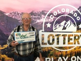 Gary E. of Weston holding an oversized check for $2,000 in front of Colorado Lottery background.