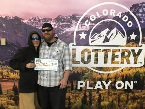 Marie A. sosteniendo el cheque gigante de $2,000 frente al fondo de Colorado Lottery