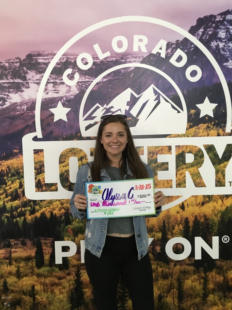 Winner holding oversized check in Colorado Lottery offices