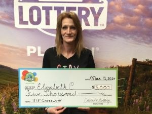 Elizabeth C. sosteniendo el cheque gigante de $5,000 frente al fondo de Colorado Lottery