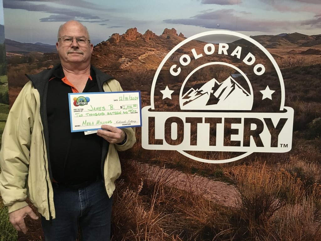 James B. holding an oversized check for $2,000 in front of Colorado Lottery background