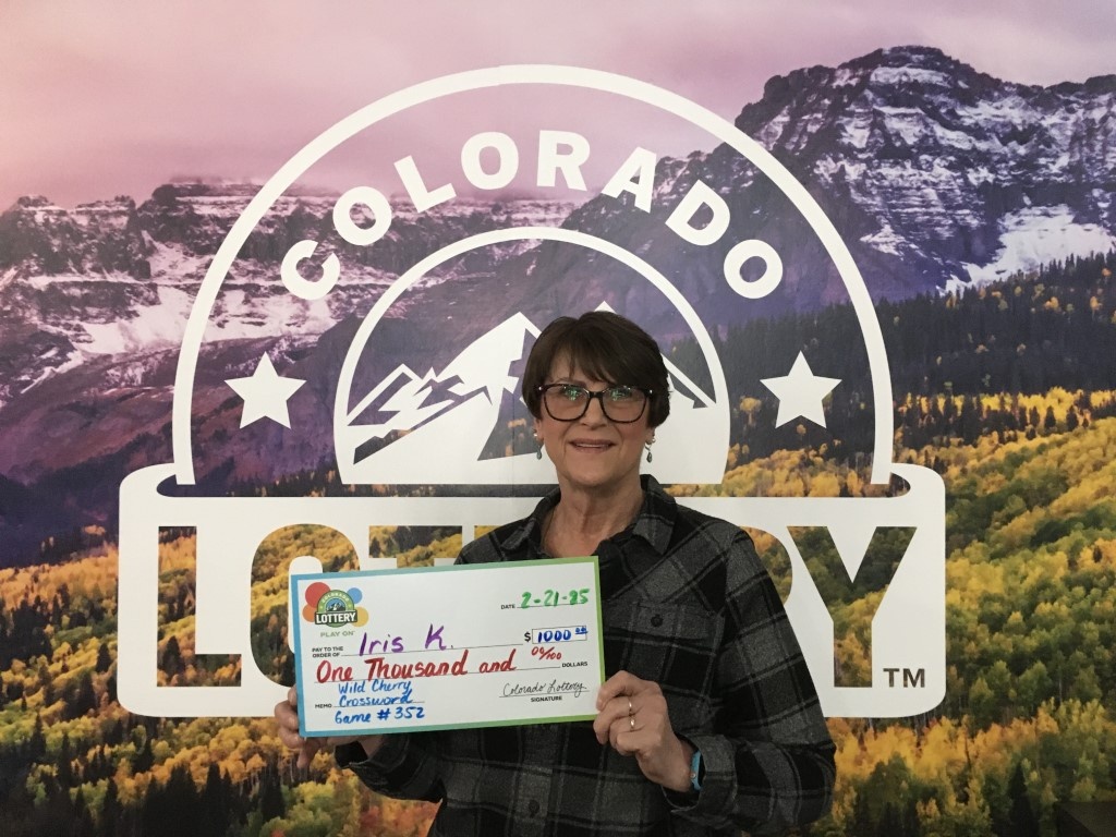 Ganador(a) con cheque de gran tamaño en las oficinas de la Lotería de Colorado