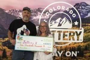 Jeffrey V. of Elbert holding an oversized check for $100,000 in front of Colorado Lottery background