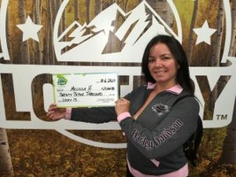 Melissa H. holding an oversized check for $23,000 in front of Colorado Lottery background