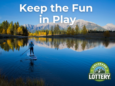 Keep the Fun  in Play. Woman paddleboarding in mountains on bright blue lake with fall leaves in background