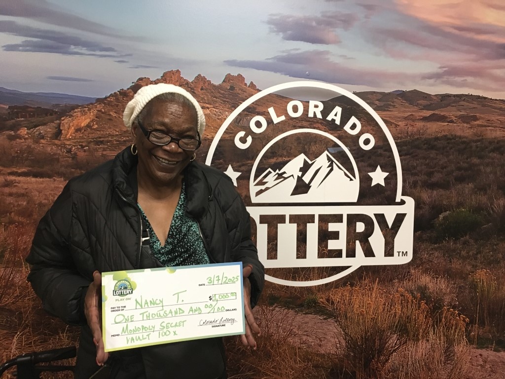 Ganador(a) con cheque de gran tamaño en las oficinas de la Lotería de Colorado