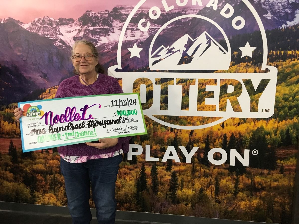 Noelle L. holding check for $100,000 in front of Colorado Lottery background