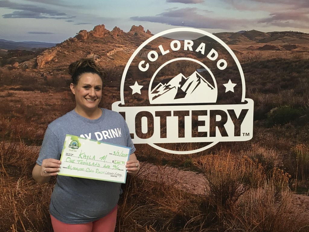 Ganador(a) con cheque de gran tamaño en las oficinas de la Lotería de Colorado