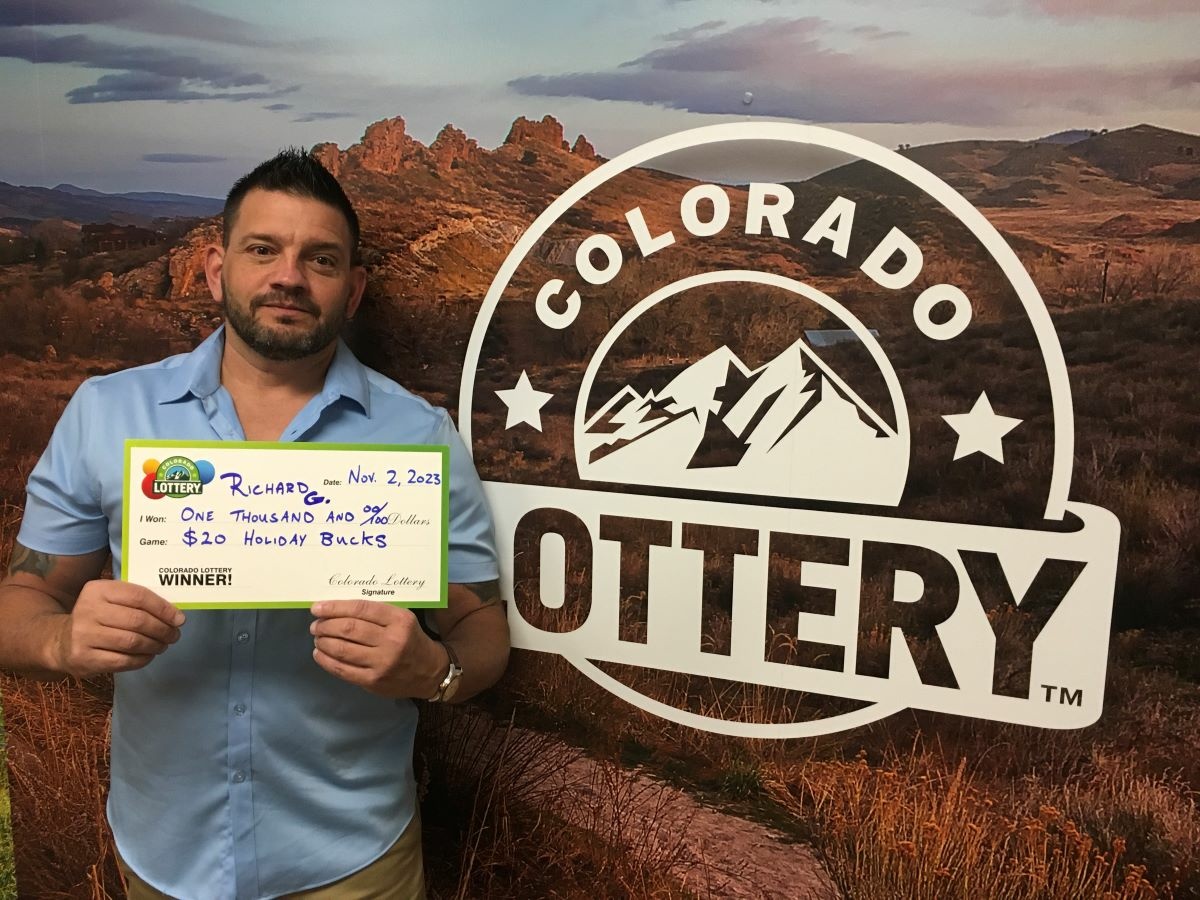 Richard G. holding check for $1,000 in front of Colorado Lottery background