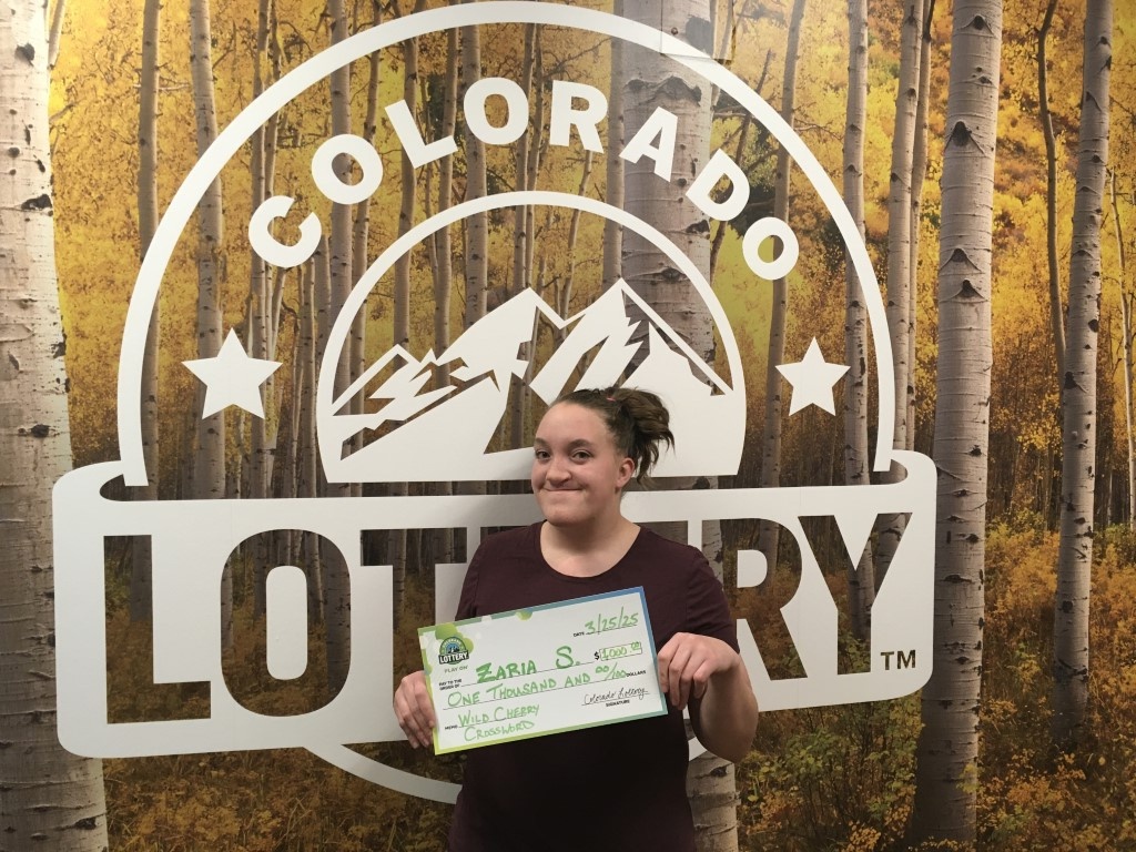 Winner holding oversized check in Colorado Lottery offices