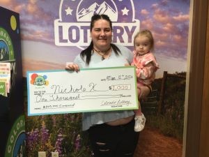 Nichole K. sosteniendo el cheque gigante de $1,000 frente al fondo de Colorado Lottery