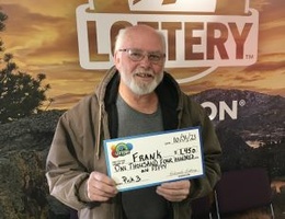 Frank H. holding check for $1,450 in front of Colorado Lottery background