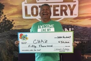 Charles A. holding check for $50,000 in front of Colorado Lottery background
