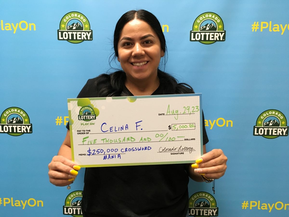 Celina F. of Denver holding an oversized check for $5,000 in front of Colorado Lottery background.